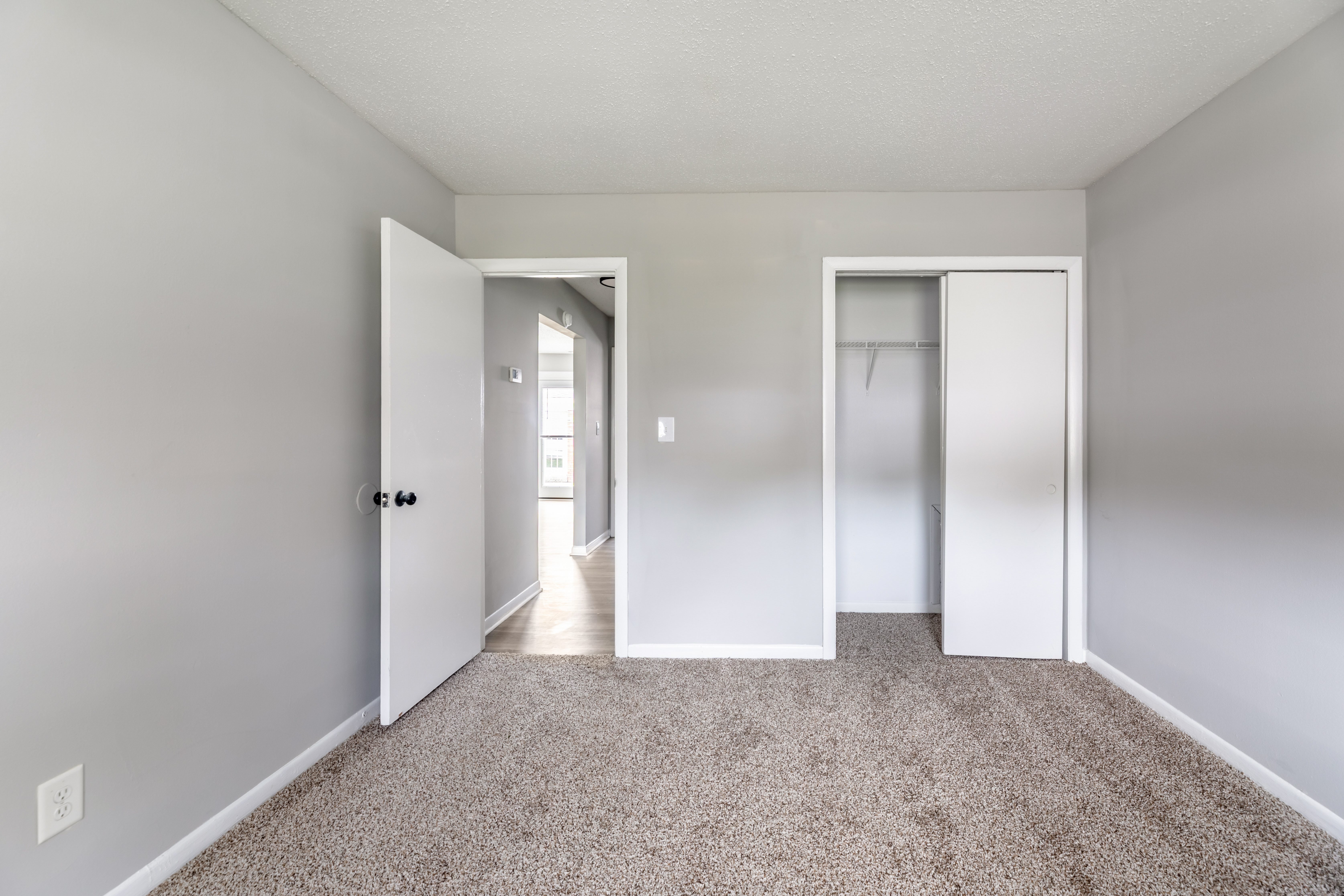 A room with a carpeted floor and two doors.at Lauradale, Jacksonville, 28540